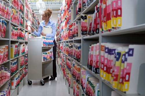 A woman organizing files of medical records.