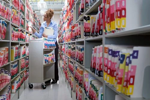 A woman organizing files of medical records.