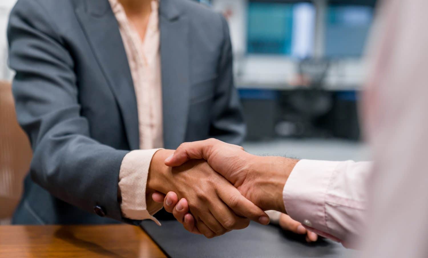 An experienced Indianapolis attorney shakes hands with a client after winning a case.