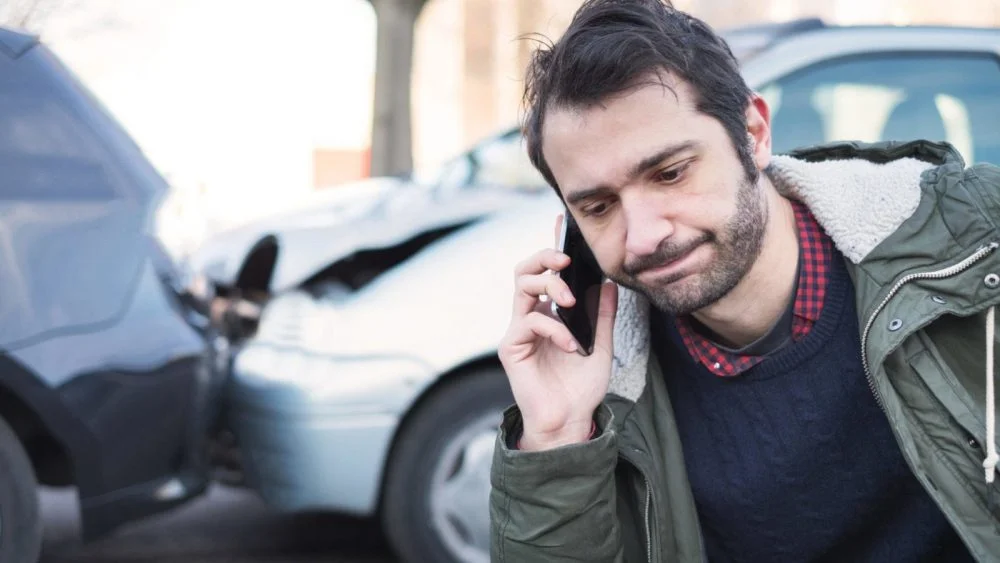 Male Driver Calling His Insurance Provider After A Car Accident Stock Photo