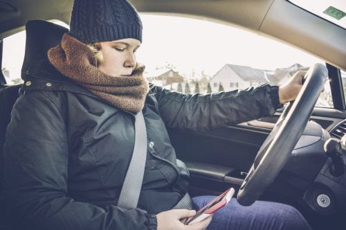 Teenage Girl Texting While Driving Her Vehicle Stock Photo