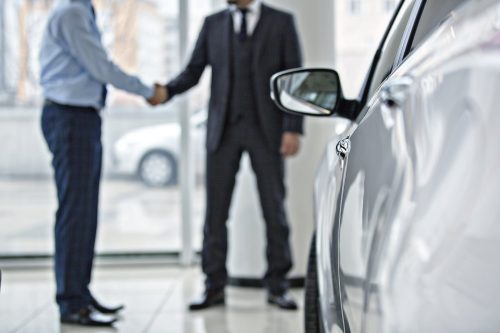 Car Buyer Shaking Hands With Car Salesman Stock Photo