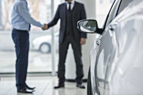 Car Buyer Shaking Hands With Car Salesman Stock Photo