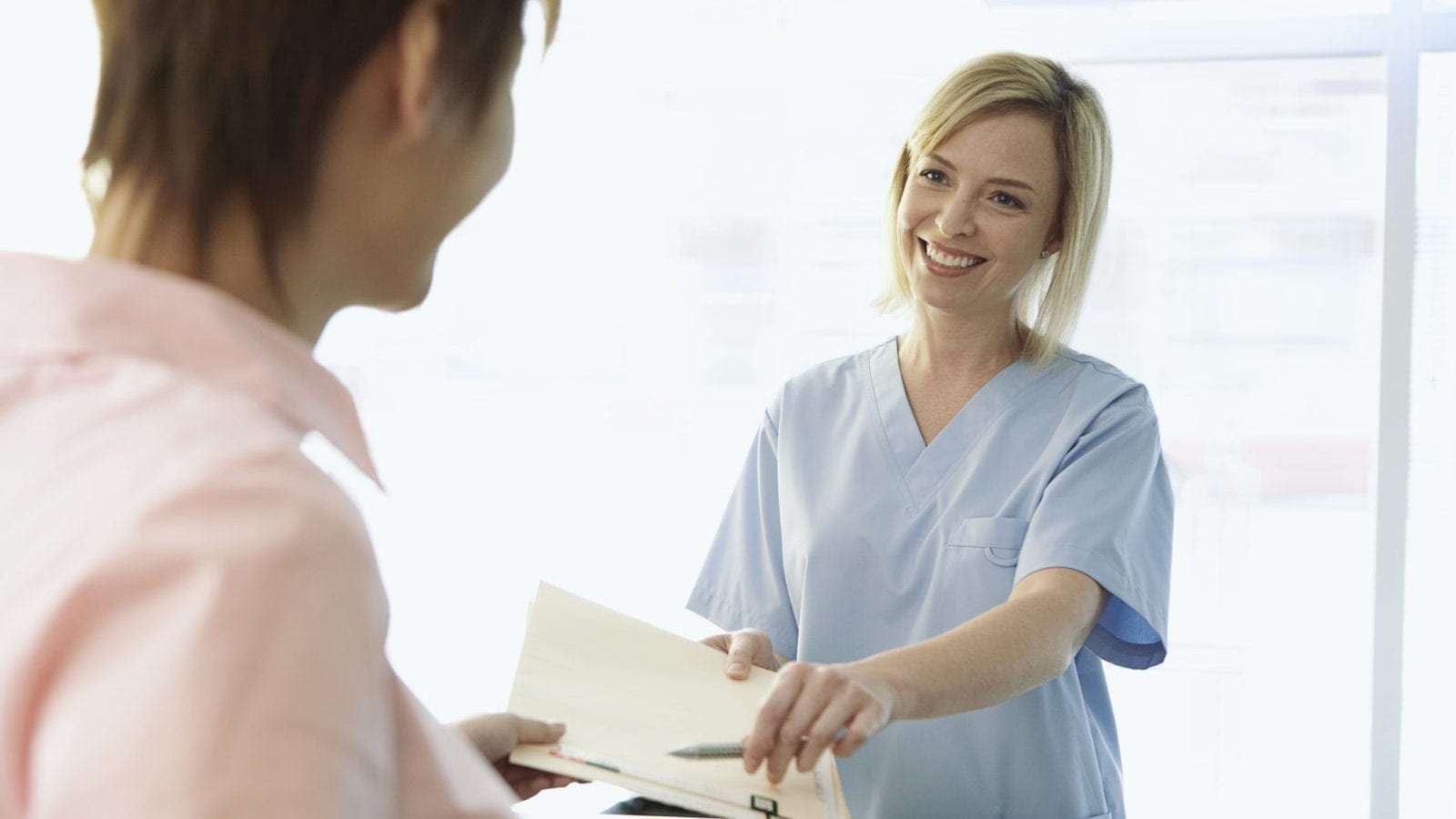 Nurse Handing A Folder To A Patient Stock Photo