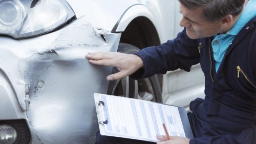 Auto Body Mechanic Writing An Estimate For Car Damage Stock Photo