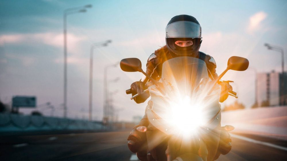 Female Motorcyclist Riding On The Highway Stock Photo