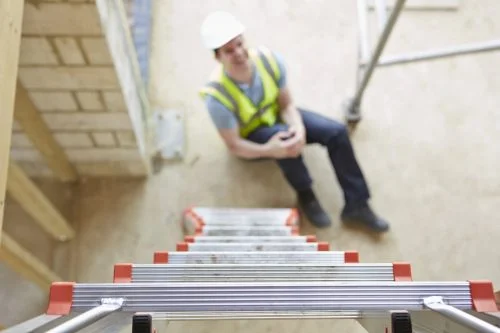Worker Falling Off Ladder And Injuring Leg Stock Photo