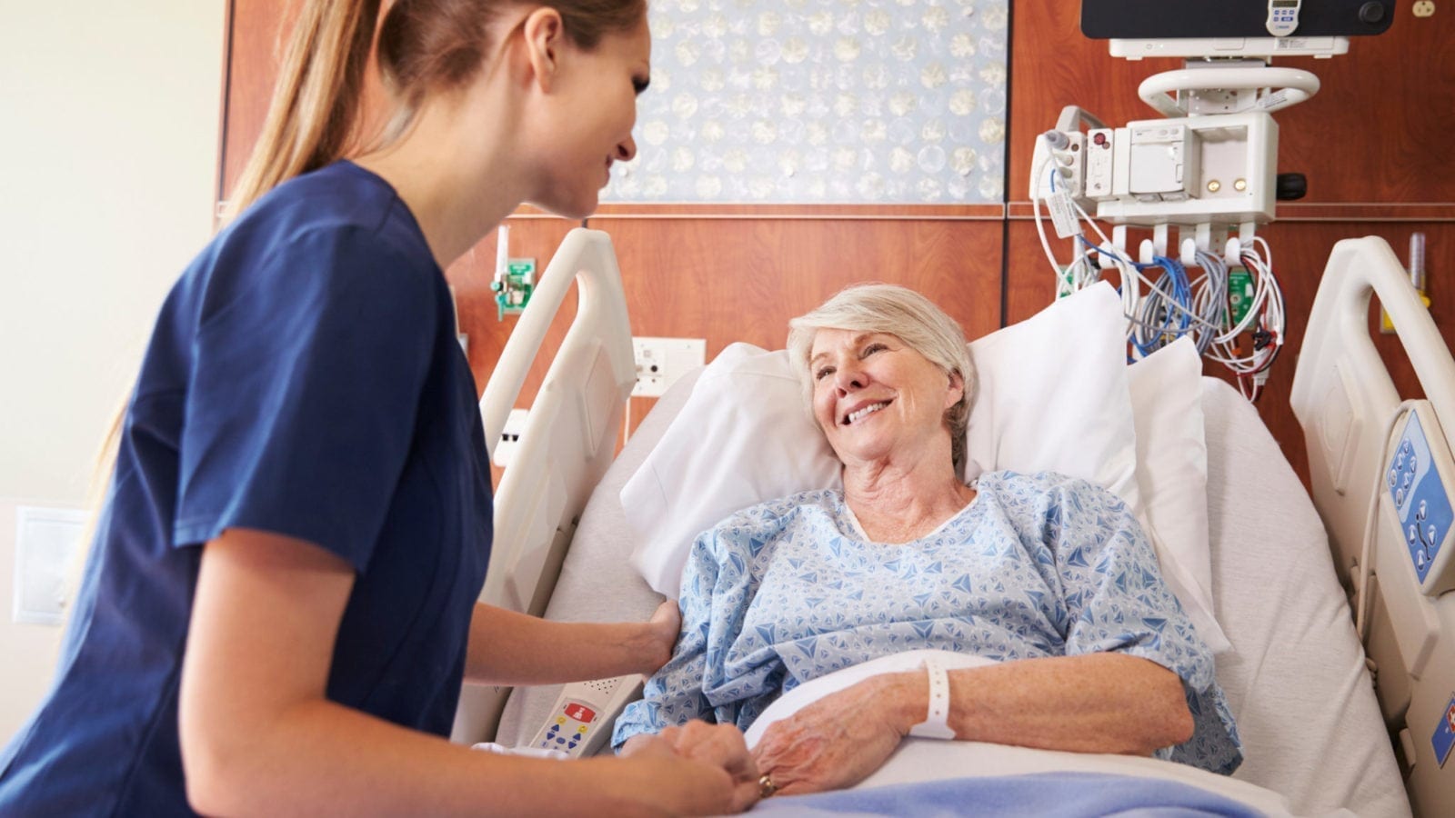 Nurse Talking To A Senior Female Patient In A Hospital Bed Stock Photo