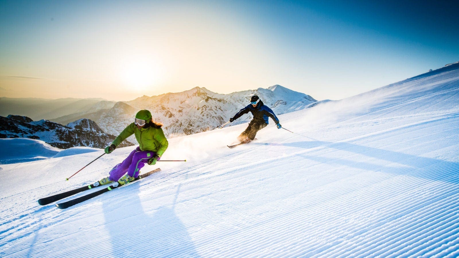 Male And Female Skiing Down A Mountain Stock Photo