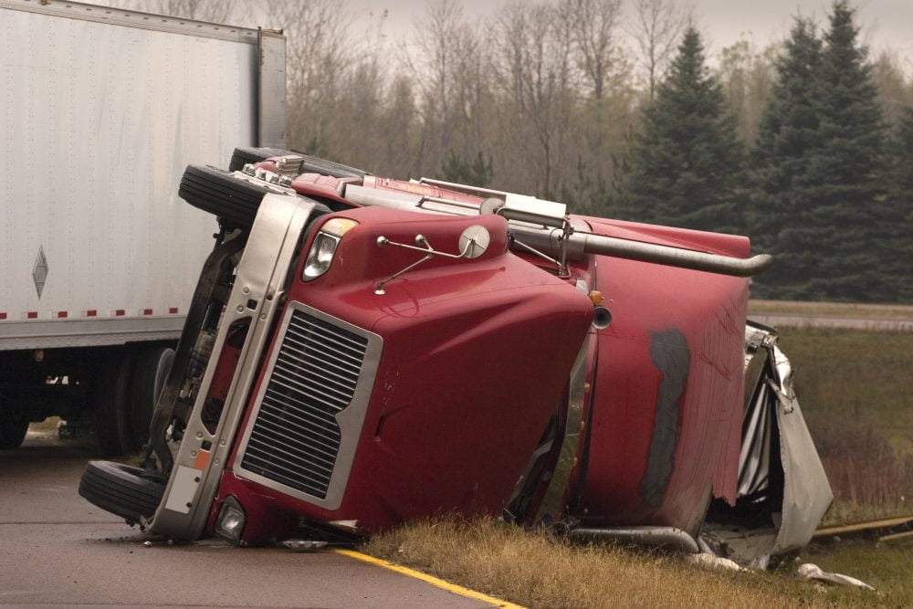 A big truck lying in the road after an accident.