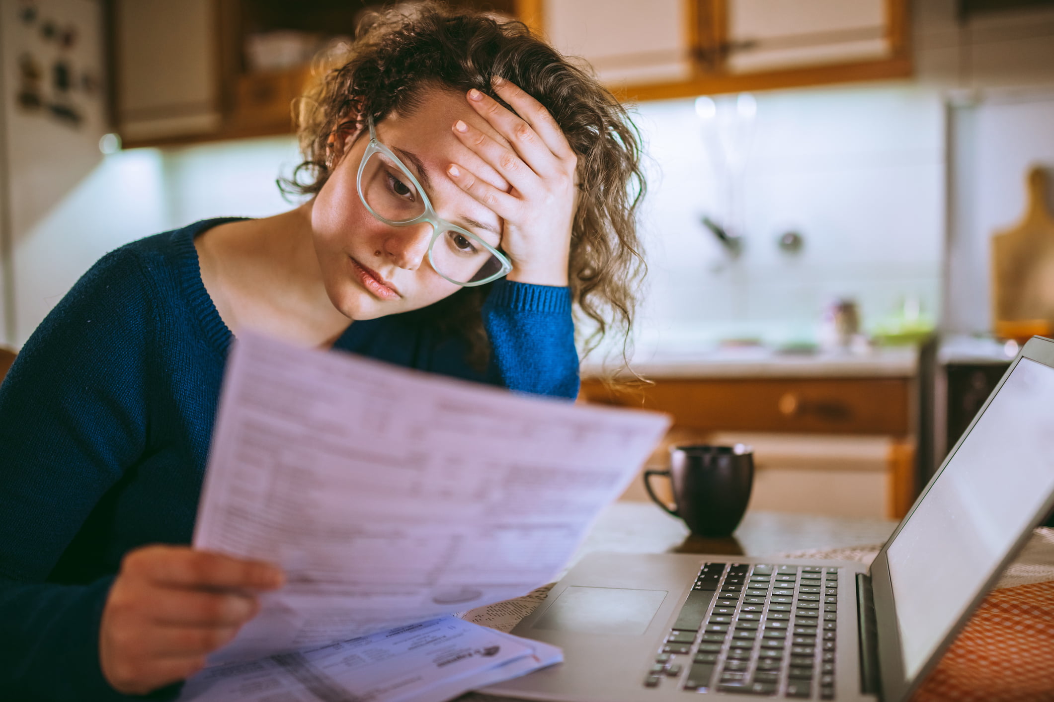 A woman feeling stressed looking at forms about her case.