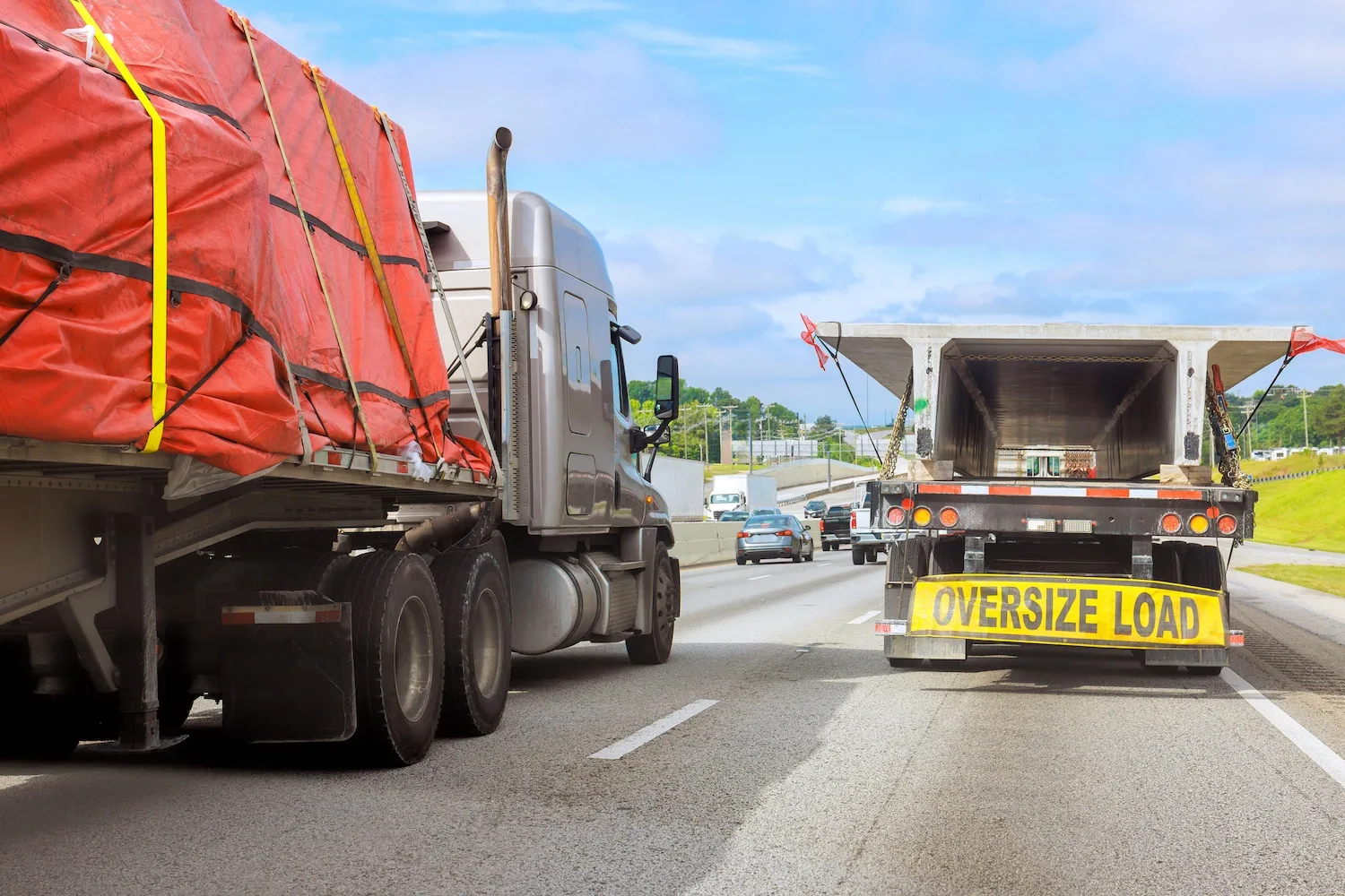 Large trucks carry oversized loads on a crowded highway.