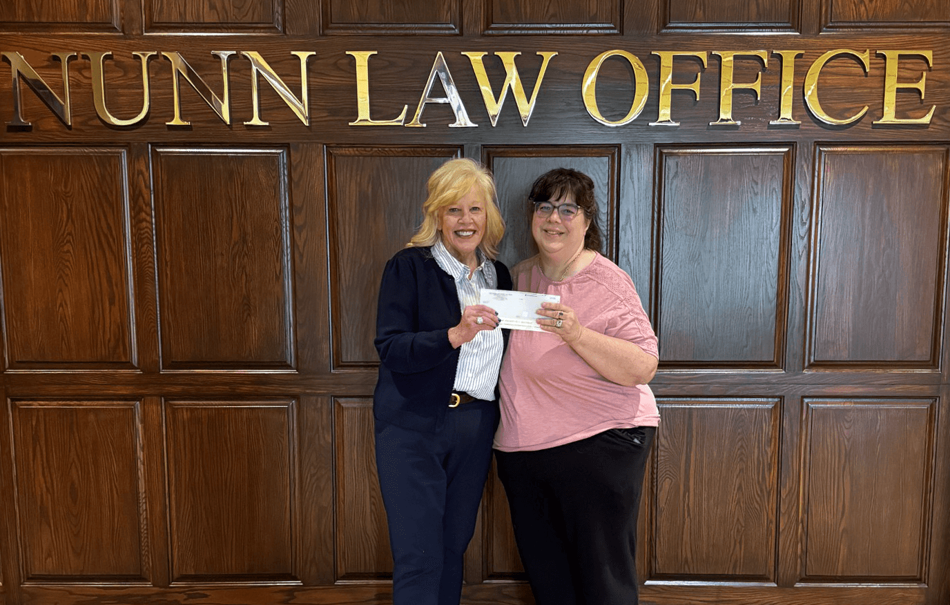 Pantry 279 receives donation from Vicky Nunn Attorney Vicky Nunn hands a representative from Pantry 279 a donation check.