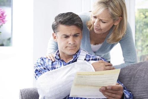 An injured man and his wife look through medical bills after an accident in Indianapolis.